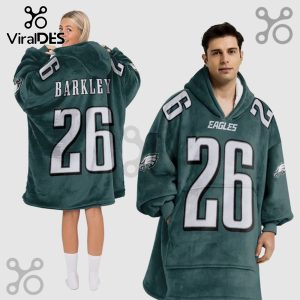 Two people wear a hooded blanket with an Eagles design, number 26, and the name Barkley on the back.!