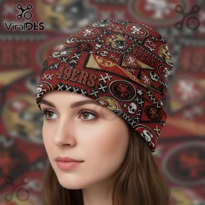 Maroon beanie with all-over print featuring 49ers logos, helmets, skull motifs, and decorative marks on a blurred background.!