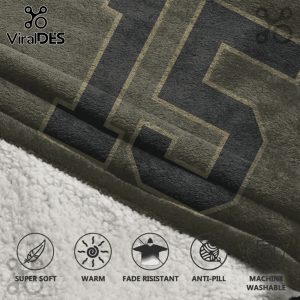 Close-up of a blanket showing a large number 15 in black with a tan outline on an olive-green blanket background.!