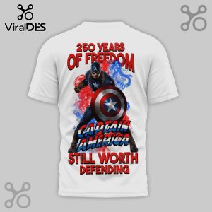 White tee w/ Captain America design. Reads '250 Years of Freedom,' & 'Still Worth Defending' in red, white, and blue fonts!