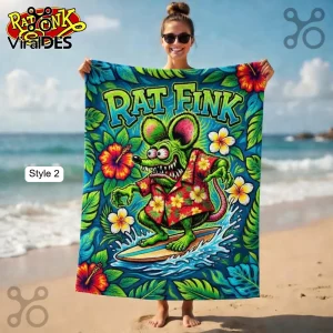 A beach towel with a Kustom Kulture illustration of a green surfing monster wearing a Hawaiian shirt and the text 'RAT FINK'!