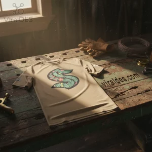 Tan shirt with large black letter S, filled with green leaves, pink flowers, and yellow berries! Botanical floral style initial tee!