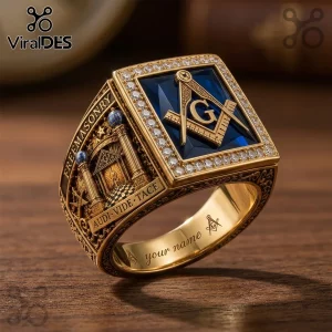 Gold Masonic ring with blue square gemstone, G symbol, diamond border, and Freemasonry text on a wooden surface!