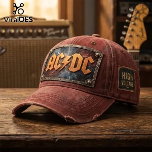 Distressed reddish-brown baseball cap with retro AC/DC logo patch featuring orange lightning bolt text and a side patch reading HIGH VOLTAGE!
