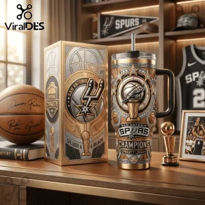 San Antonio Spurs championship tumbler with gold and silver embossed basketball, trophy, and team logos on a wooden desk.!