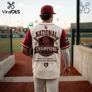 Oklahoma Sooners baseball jersey with National Champions graphics in crimson and cream on a player at a stadium.!