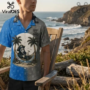 Man wearing a blue and grey short-sleeve button-up shirt featuring a ghost character in a hammock with palm trees.!