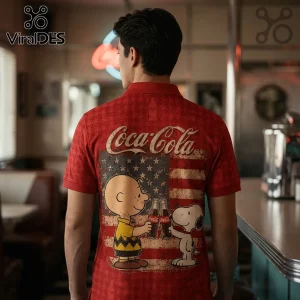 Red polo shirt featuring Charlie Brown and Snoopy holding Coca-Cola bottles over a distressed American flag background.!