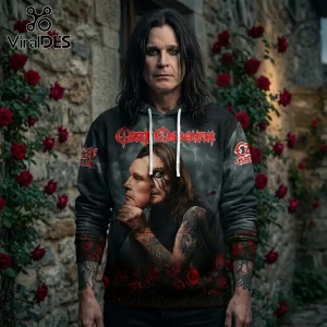 Man wearing black hoodie with Ozzy Osbourne graphic, portrait of Ozzy holding a mask, and rose print against stone wall.!