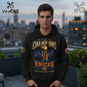 Man wearing black hoodie with 2025-26 New York Knicks basketball championship graphic and NYC skyline backdrop.!