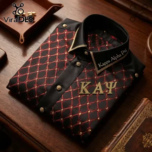 Black long-sleeve dress shirt with red diamond embroidery, Kappa Alpha Psi Greek letters, and gold buttons on wood desk.!