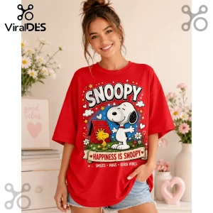 Woman wearing oversized red t-shirt with graphic print of Snoopy, Woodstock, and text Happiness Is Snoopy.!