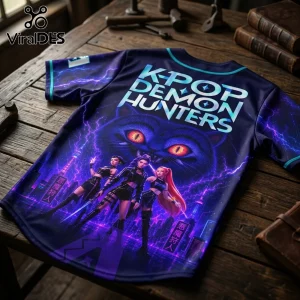 K-pop Demon Hunters jersey featuring three female characters, a giant cat face, and purple lightning on a dark blue background.!