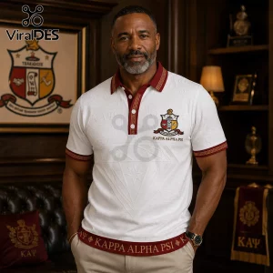 Middle-aged man wearing a white polo shirt with burgundy trim, Kappa Alpha Psi emblem, and Greek letter embroidery.!