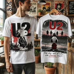 White crewneck t-shirts featuring U2 band graphics and Snoopy illustrations on a model in a rustic coffee shop setting.!