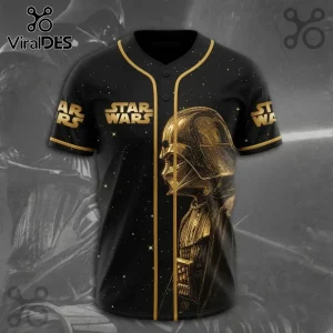 Black baseball jersey with gold Star Wars logo and side-profile gold Darth Vader helmet graphic on a star-patterned background.!