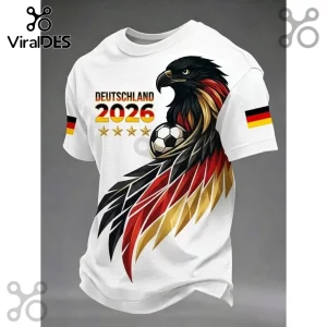 White t-shirt featuring a German eagle with black, red, and gold wings, a soccer ball, and Germany 2026 text with stars.!