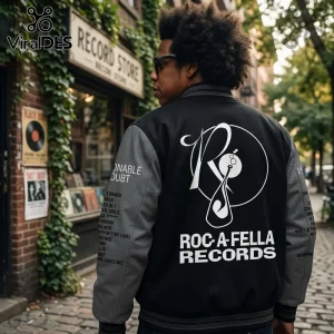 Jay-Z wearing a black and gray Roc-A-Fella Records varsity jacket with logo on back and tracklist text on the sleeves.!