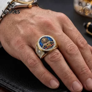 Gold Iron Maiden 50th anniversary ring with Eddie graphic, blue enamel inlay, and crystal accents on a man's finger.!
