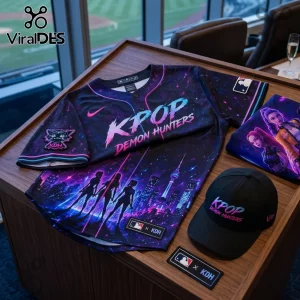KPOP Demon Hunters baseball jersey and matching cap with neon city skyline and character graphics on a wooden table.!