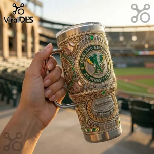 Oakland Athletics metal travel tumbler with elephant logo, baseball patterns, and gold filigree held in front of stadium.!