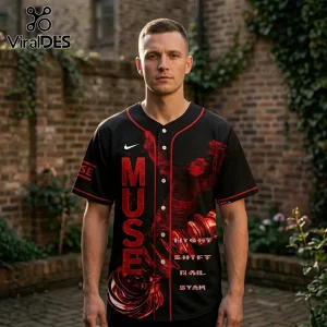 Man wearing a black baseball jersey with red abstract spiral graphics, Muse text, and white Nike logo against brick wall.!