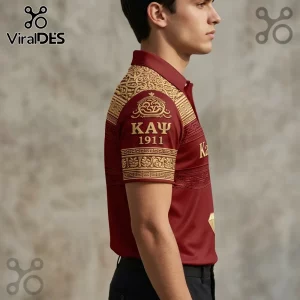 Maroon polo shirt with gold Greek key patterns and Kappa Alpha Psi 1911 embroidery worn by a man against a grey wall.!
