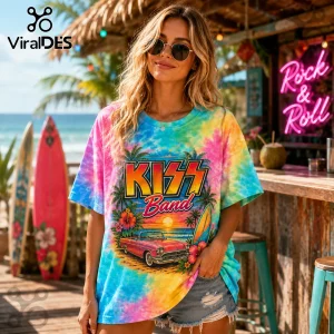 Woman wearing a tie-dye t-shirt with a KISS Band graphic, vintage pink car, sunset beach scene, and palm trees.!