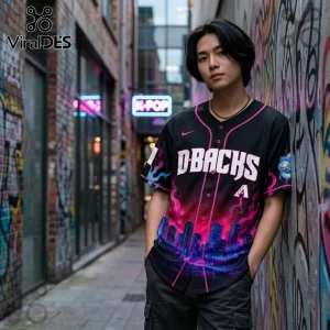 Man wearing black Arizona D-Backs baseball jersey with pink city skyline graphic standing in a graffiti alleyway.!