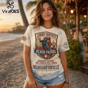 Woman wearing a cream-colored t-shirt featuring a parrot with binoculars, beach graphics, and Jimmy Buffett text.!