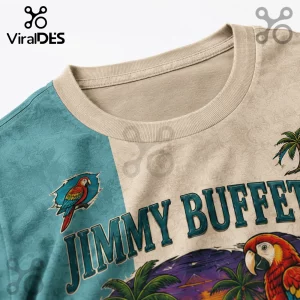 Beige and teal crew neck t-shirt with Jimmy Buffett graphic, macaw parrot illustrations, palm trees, and tropical scenery.!