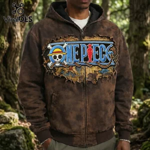 Brown acid-wash zip-up hoodie featuring a distressed One Piece logo patch with skull emblem on a blurred forest background.!