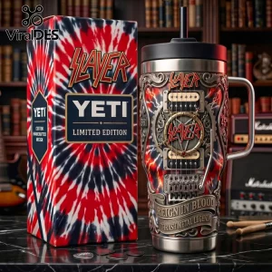 Slayer branded metal tumbler with guitar motif, red and black tie-dye box, and three guitar picks on black marble table.!