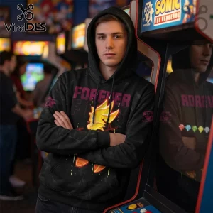 Man wearing a black pullover hoodie featuring a yellow Super Sonic graphic and Forever Fast text in an arcade setting.!