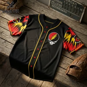 Black baseball jersey with yellow trim, red buttons, and Grateful Dead stealie logo on chest and patterned sleeves.!