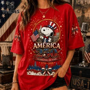 Red cotton t-shirt featuring Snoopy in a top hat holding an American flag with America 250 and 1776-2026 text graphics.!