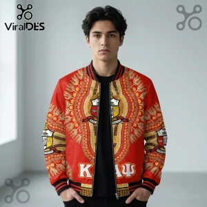 Man wearing red Kappa Alpha Psi bomber jacket with gold African-inspired patterns and fraternity crests on chest.!
