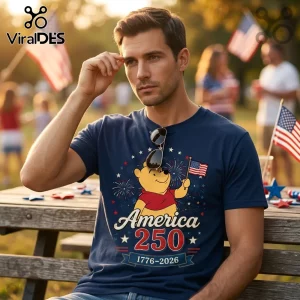 Man wearing a navy t-shirt featuring Winnie the Pooh holding a US flag with America 250 and 1776-2026 text graphics.!