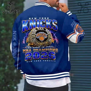 New York Knicks 2026 championship bomber jacket featuring a gold ring graphic, blue fabric, and skyline detailing.!