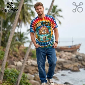 Man wearing a One Piece anime tie-dye t-shirt featuring the Straw Hat pirate logo and text on a tropical beach background.!