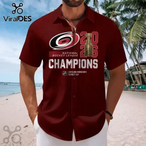 Maroon short-sleeve button-down shirt featuring a Carolina Hurricanes logo, Stanley Cup graphic, and Champions text.!