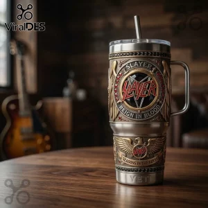 Slayer band Yeti tumbler with metal embossed logo, wings, and Reign in Blood text on a dark wooden table.!