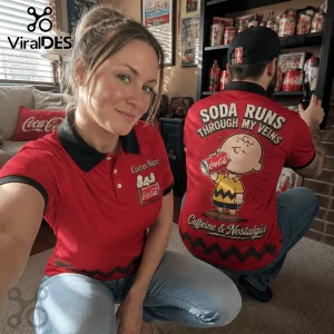 Man and woman wearing red Coca-Cola polo shirts featuring Charlie Brown holding a soda can and custom name embroidery.!