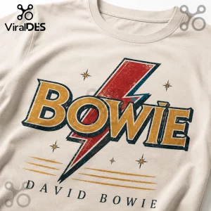 Off-white cotton t-shirt with a distressed red lightning bolt and gold Bowie text graphic with black stars.!
