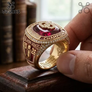 Oklahoma Sooners 2026 NCAA championship ring featuring gold band, red center stone, white accents, and engraved text.!