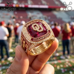 Gold Oklahoma Sooners 2026 NCAA National Champions ring with a large red center stone and inset clear crystals.!