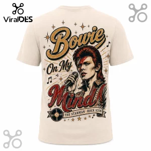 David Bowie graphic t-shirt in cream featuring his Ziggy Stardust persona, red lightning bolt, microphone, and music notes.!
