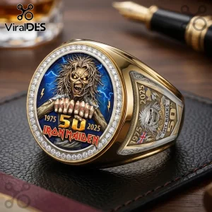 Gold Iron Maiden 50th anniversary championship ring featuring Eddie, lightning, diamonds, and dates 1975-2025 on a black mat.!