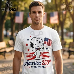 Man wearing white t-shirt with Snoopy holding US flag, American stars, and text America 250th 1776-2026.!