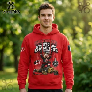 Man wearing red pullover hoodie featuring Carolina Hurricanes 2026 Stanley Cup Champions graphic print.!